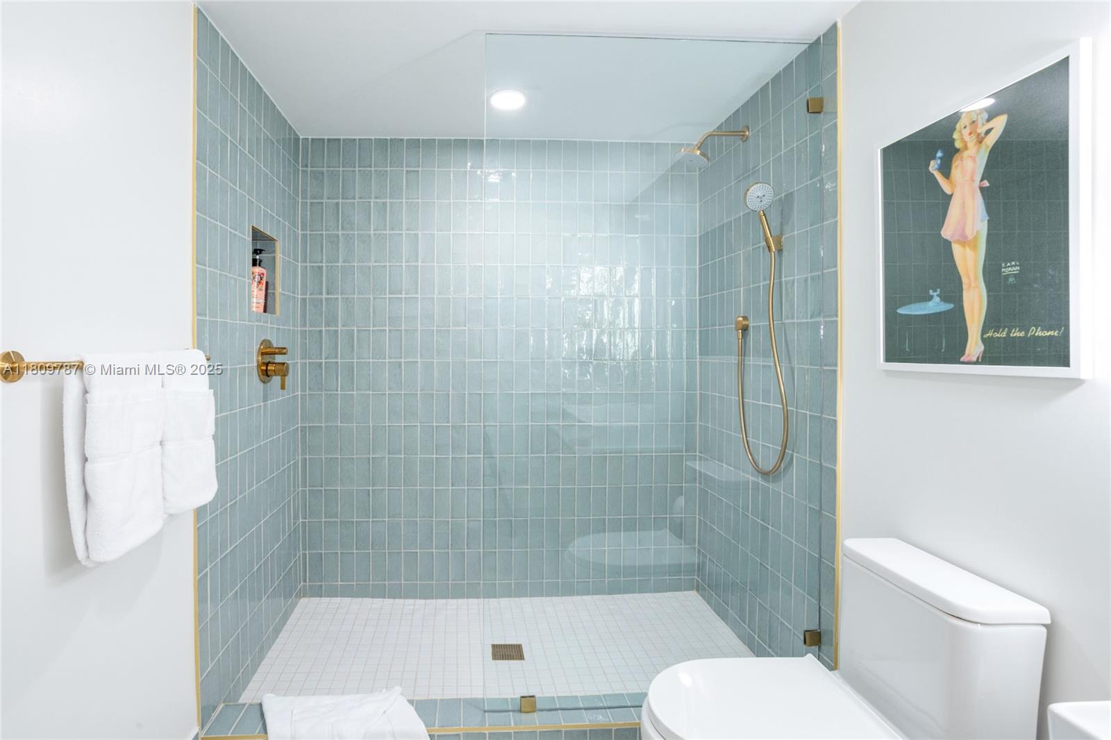 A bathroom features a glass-enclosed shower with light blue vertical tiles and gold fixtures — 159 NE 6th St # 2901, Miami FL 33132, MIAMI, FL