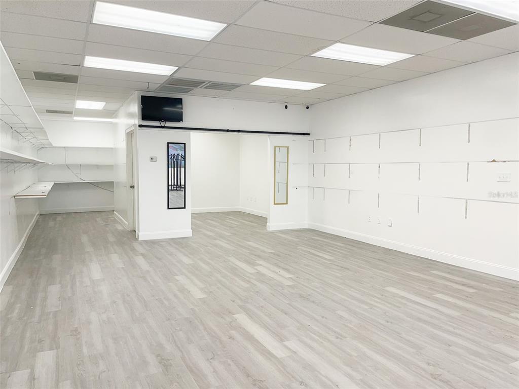 An empty commercial space features white walls, light wood-look flooring, and recessed ceiling lighting — 5508 US HIGHWAY 98 N, LAKELAND, FL