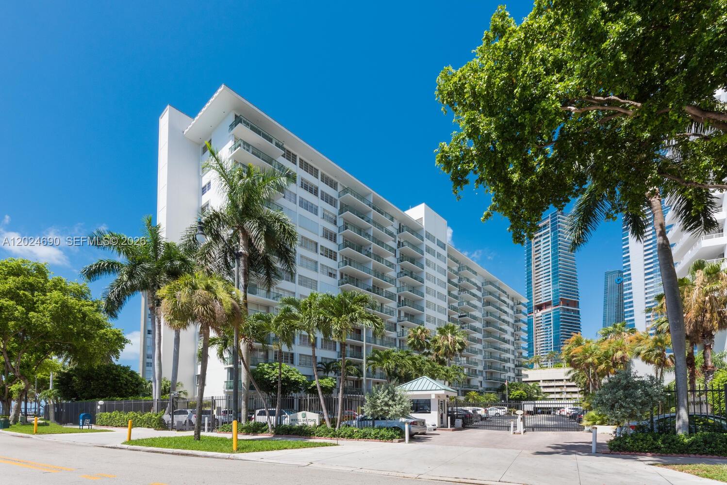A balcony with green railings overlooks a bay and a neighboring high-rise building — 1408 Brickell Bay Dr # 1116, Miami FL 33131, MIAMI, FL