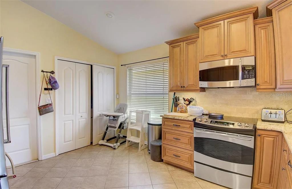 A kitchen with wood cabinets, granite countertops, stainless steel appliances, and tile flooring — 3137 CASTLE ROCK CIRCLE, LAND O LAKES, FL