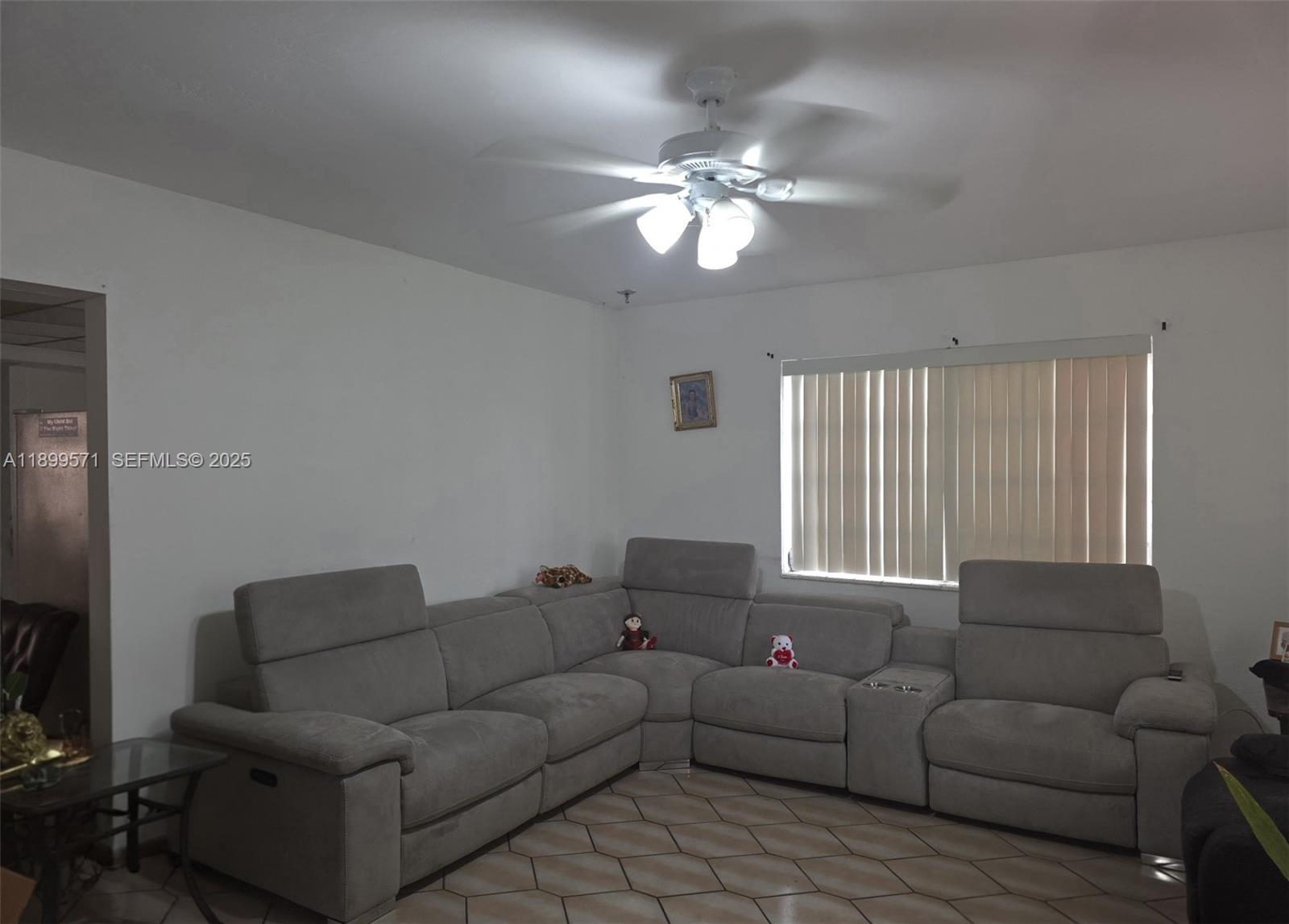 A living room features a large gray sectional sofa, tile flooring, and a ceiling fan — 250 NW 63rd Ct, Miami FL 33126, MIAMI, FL