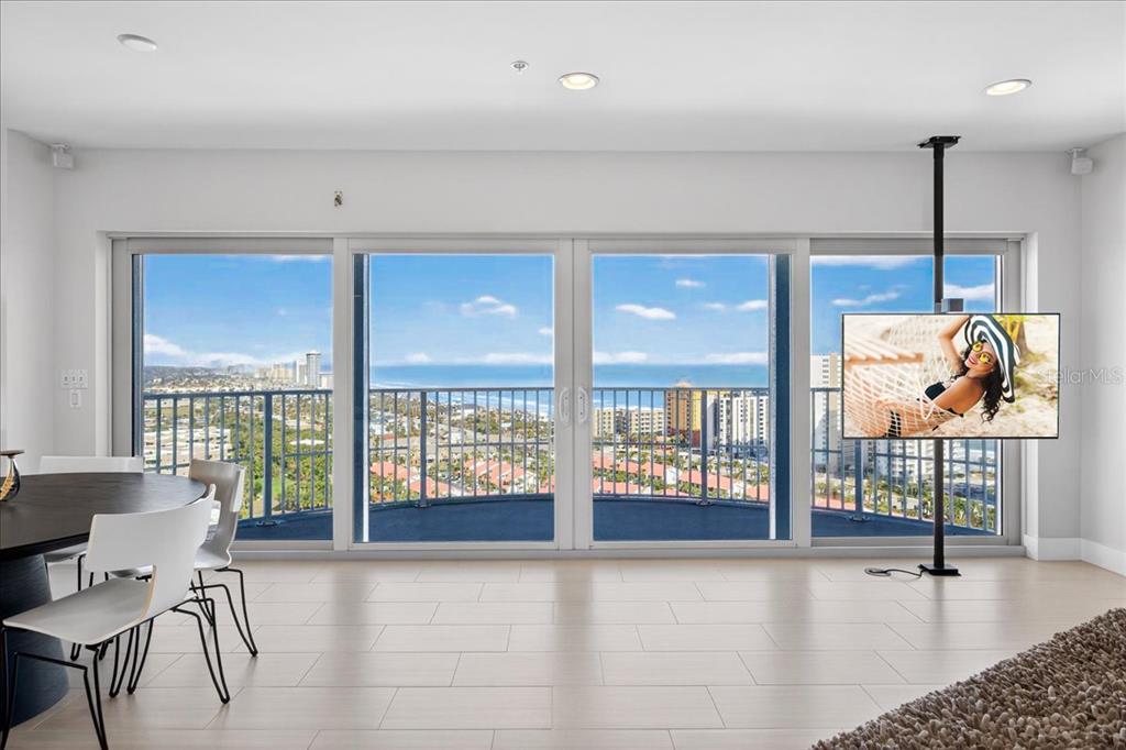 A dining area with a floor-to-ceiling window wall overlooking the ocean and city skyline — 2 OCEANS WEST BOULEVARD UNIT 2006, DAYTONA BEACH, FL