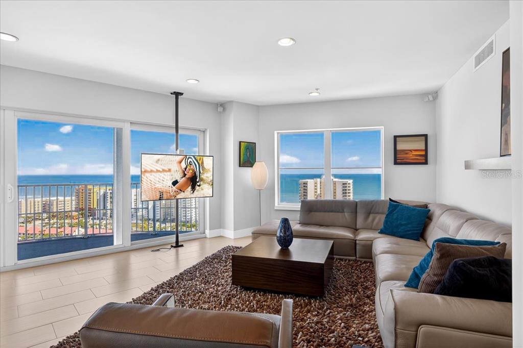 A living room features a sectional sofa, a coffee table, and a floor-to-ceiling ocean view — 2 OCEANS WEST BOULEVARD UNIT 2006, DAYTONA BEACH, FL