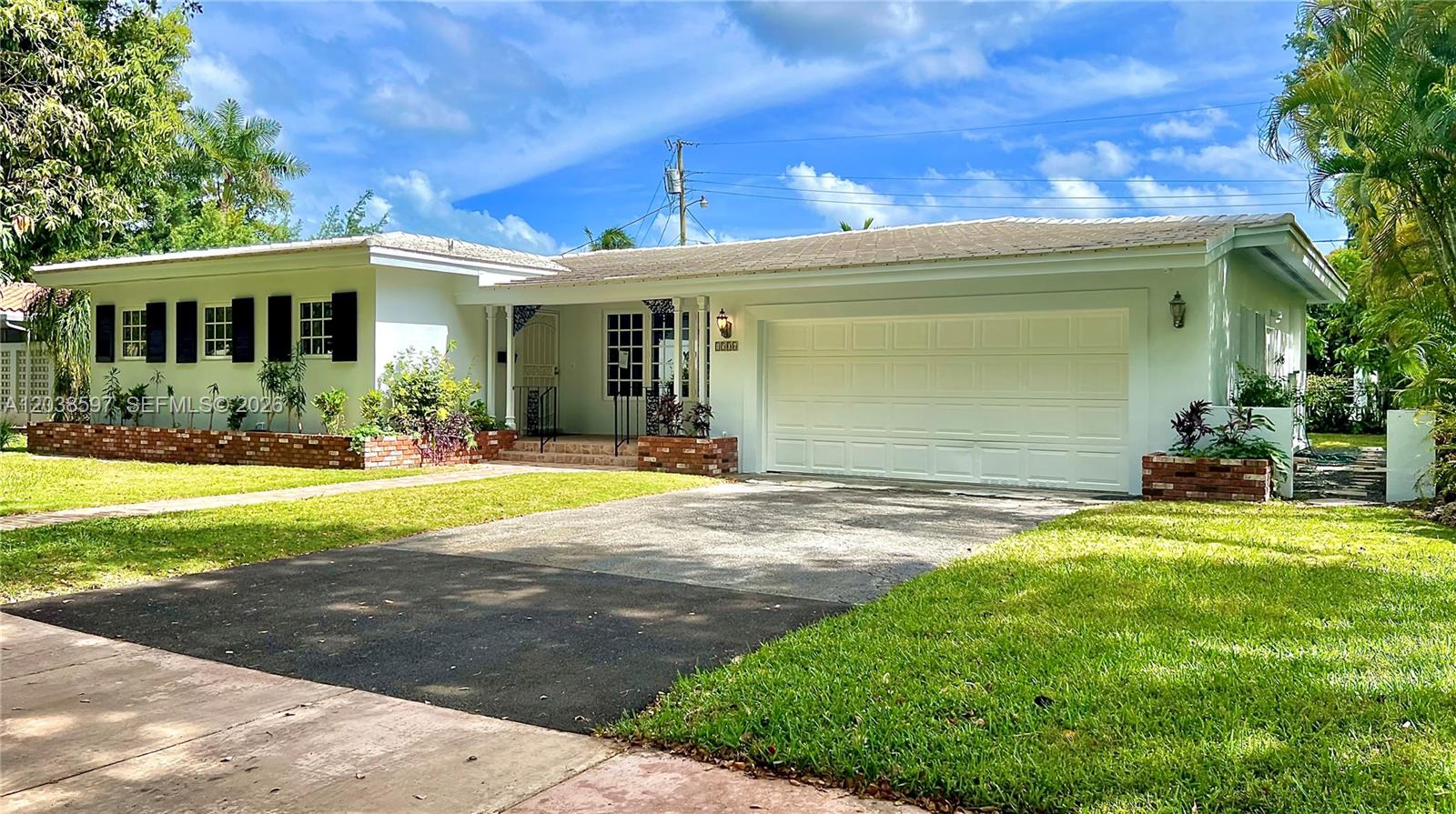 A single-story house features a white exterior, a two-car garage, and a brick planter — 1506 Delgado Ave, Coral Gables FL 33146, CORAL GABLES, FL