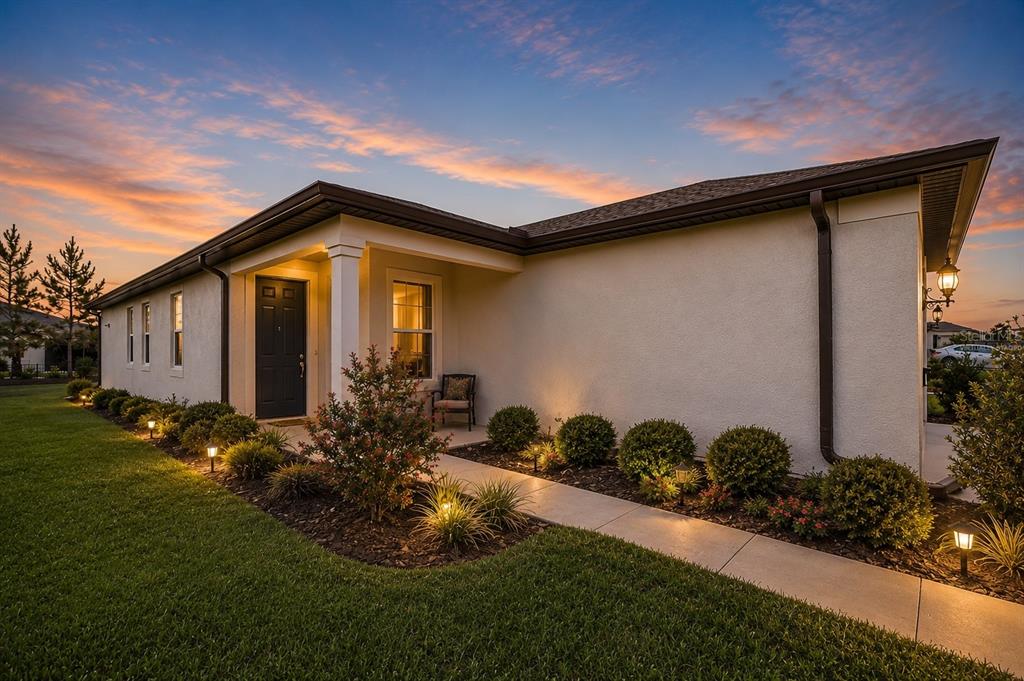 A single-story house with a beige stucco exterior, dark trim, and a landscaped front walkway — 9412 SW 53RD PLACE, OCALA, FL