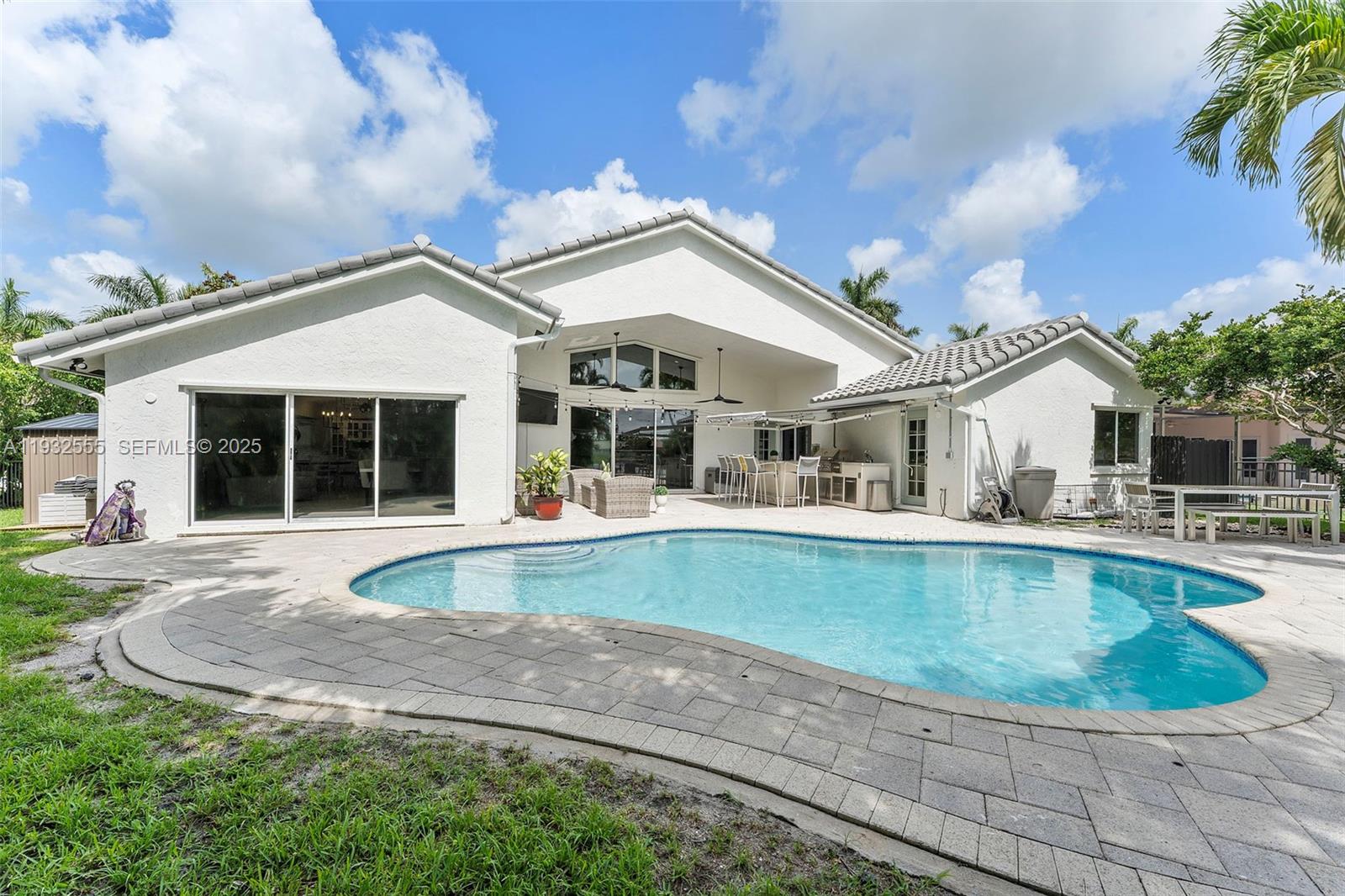 A white house with a swimming pool and a paved patio area in the backyard — 550 NW 110th Ave, Plantation FL 33324, PLANTATION, FL