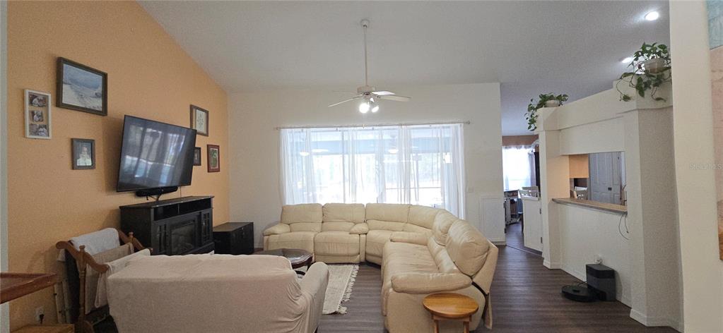 A living room features a sectional sofa, a television on a stand, and vaulted ceilings — 27 GRASS STREET, HOMOSASSA, FL