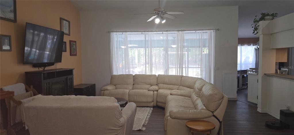 A living room features a large sectional sofa, a wall-mounted television, and a ceiling fan — 27 GRASS STREET, HOMOSASSA, FL