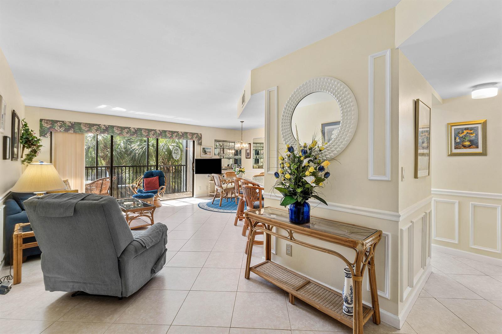 A living and dining area features tile flooring, a rattan console table, and a balcony — 1605 S Us Highway 1 # D302, Jupiter FL 33477, JUPITER, FL
