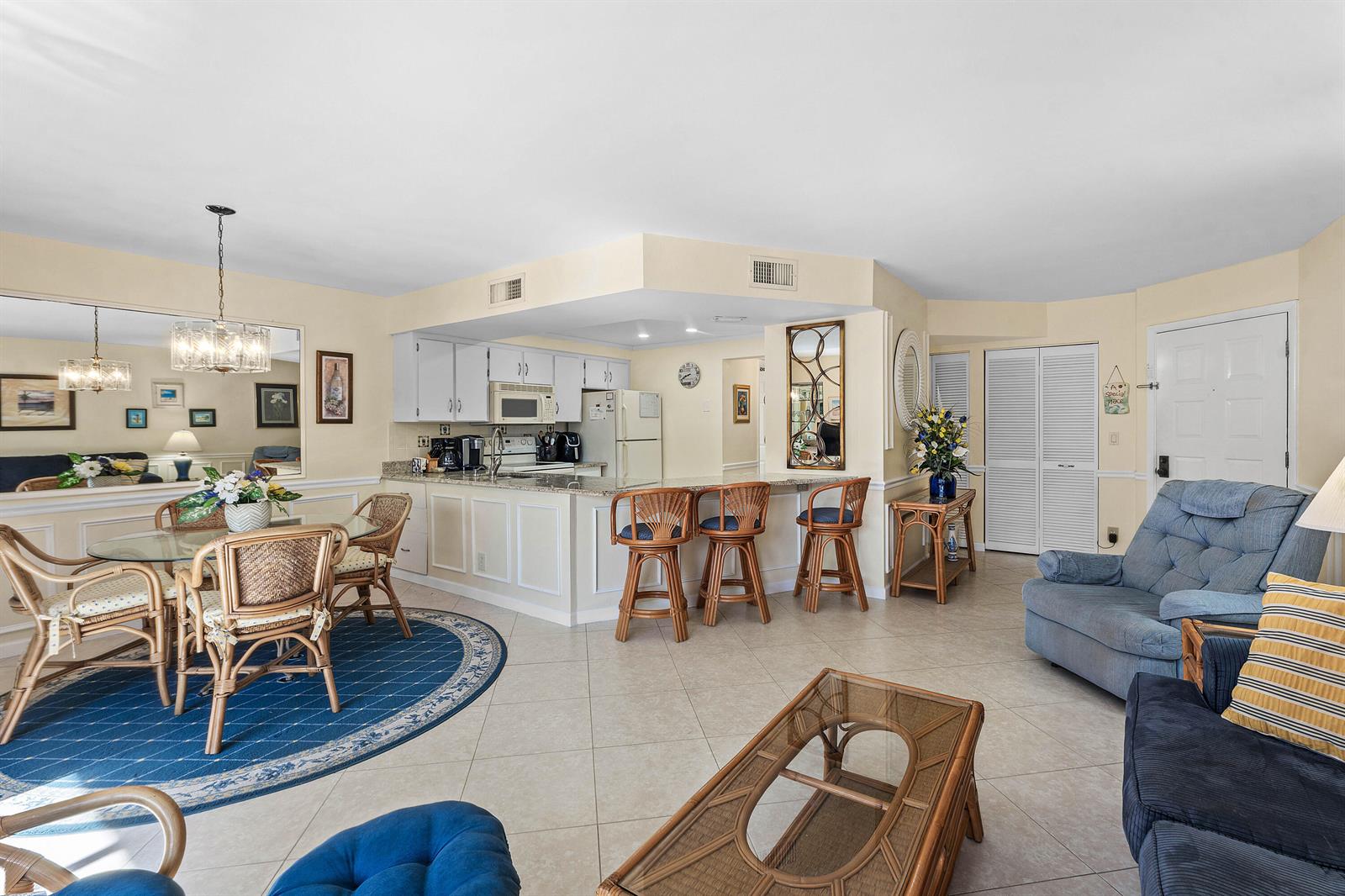 An open-concept living and dining area features a kitchen with a breakfast bar and tile flooring — 1605 S Us Highway 1 # D302, Jupiter FL 33477, JUPITER, FL