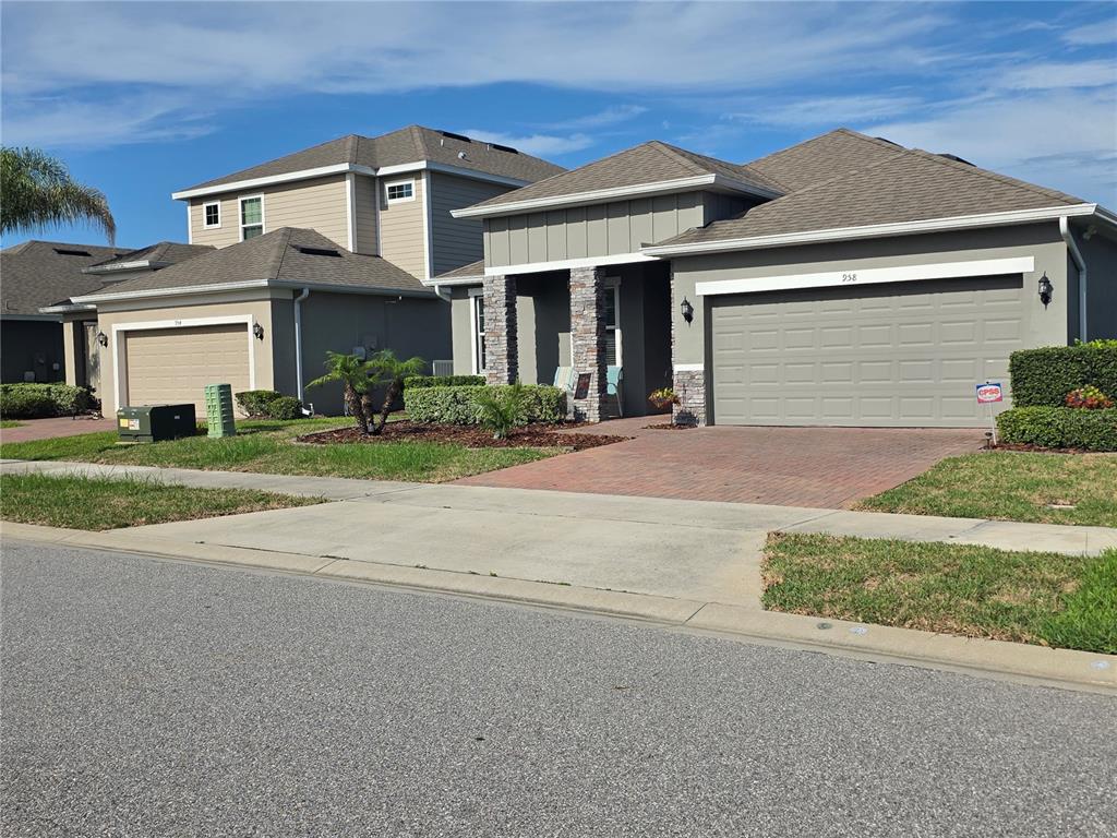 A kitchen features white cabinets, stainless steel appliances, a center island, and light-colored flooring — 958 COMPASS LANDING DRIVE, ORANGE CITY, FL