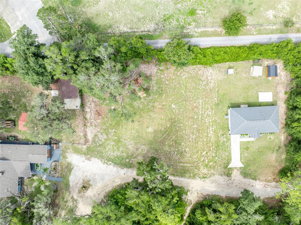 An aerial view shows a large grassy lot with two houses, several outbuildings, and trees — SE 105TH TERRACE, OCKLAWAHA, FL