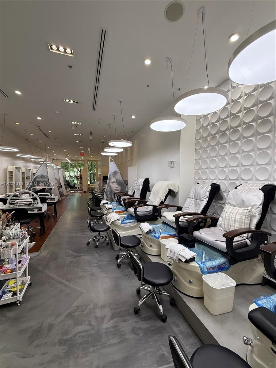 A modern nail salon features rows of pedicure chairs and manicure stations with pendant lighting — Beauty Salon & Spa in Brickell, Miami FL 33131, MIAMI, FL