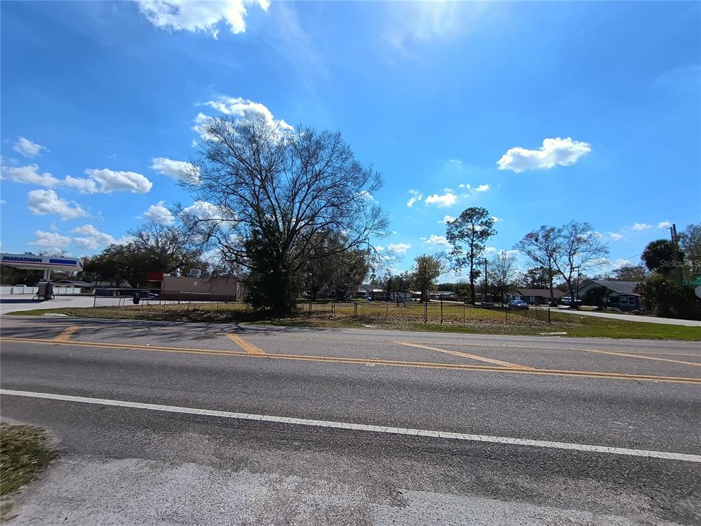 A vacant, grassy lot sits beside a Marathon gas station under a blue sky — 5574 S ORANGE BLOSSOM TRAIL, INTERCESSION CITY, FL