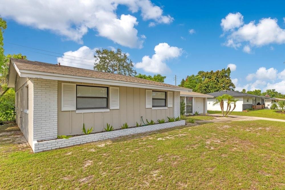 A single-story house with tan vertical siding, white brick accents, and a shingled roof — 3021 PLAZA TERRACE DRIVE, ORLANDO, FL