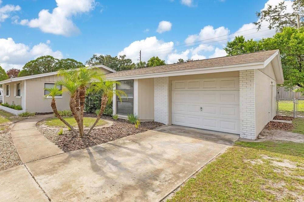 A single-story house with a white brick garage, beige siding, and a palm tree out front — 3021 PLAZA TERRACE DRIVE, ORLANDO, FL