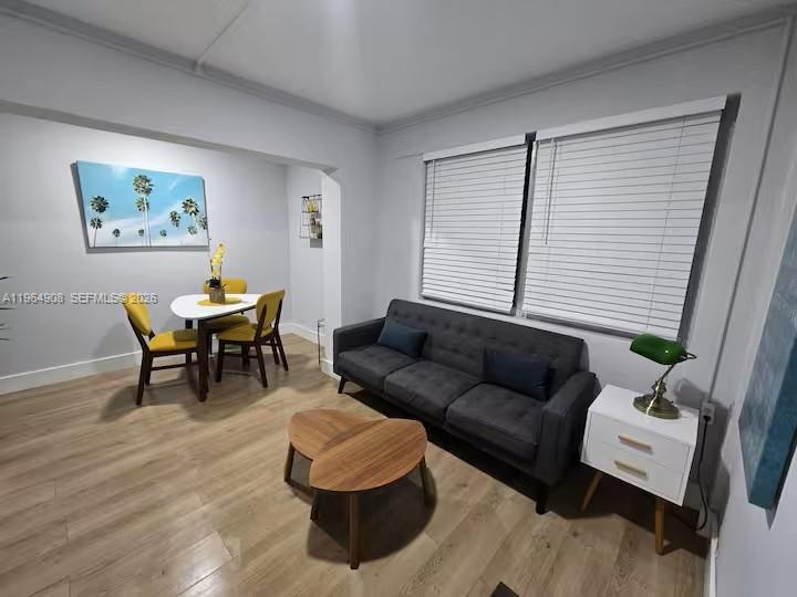 A living and dining area features light wood floors, a gray sofa, and yellow chairs — 845 NW 3rd St # C, Miami FL 33128, MIAMI, FL