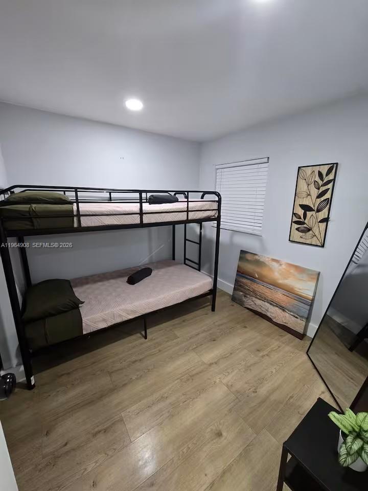 A bedroom features a black metal bunk bed, light wood flooring, and wall art — 845 NW 3rd St # C, Miami FL 33128, MIAMI, FL