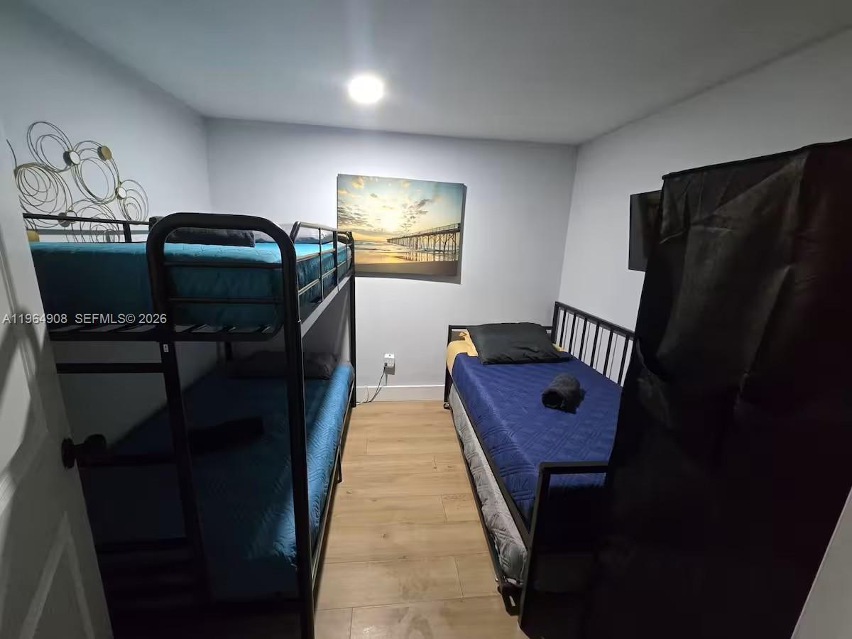 A bedroom features a metal bunk bed, a single bed, and a wall-mounted landscape print — 845 NW 3rd St # C, Miami FL 33128, MIAMI, FL