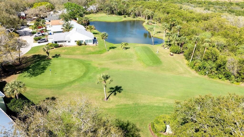 An aerial view shows a golf course green and fairway adjacent to a pond and houses — SEBASTIAN, FL