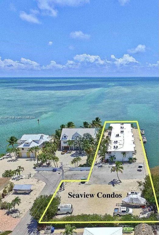 An aerial view shows a coastal property with a long building and parking area — 1215 97th Street Ocean # 11, Marathon FL 33050, MARATHON, FL