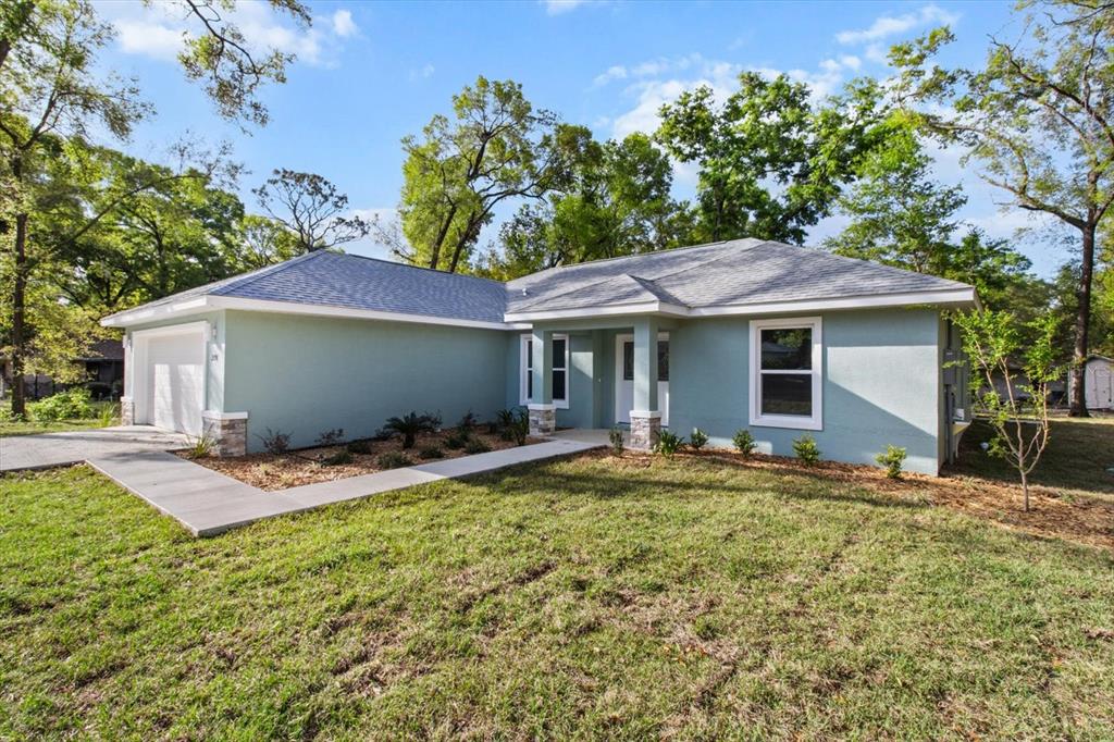 A light green, single-story suburban house with a gray roof and a concrete walkway — 2396 W FAIRWAY LOOP, CITRUS SPRINGS, FL