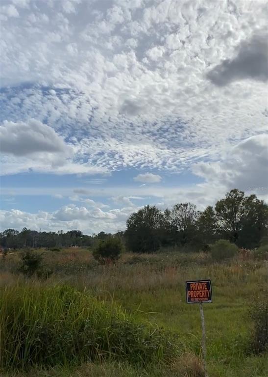 A grassy, undeveloped lot features a private property sign under a cloudy sky — 0 ALLISON AVENUE, LAKE WALES, FL