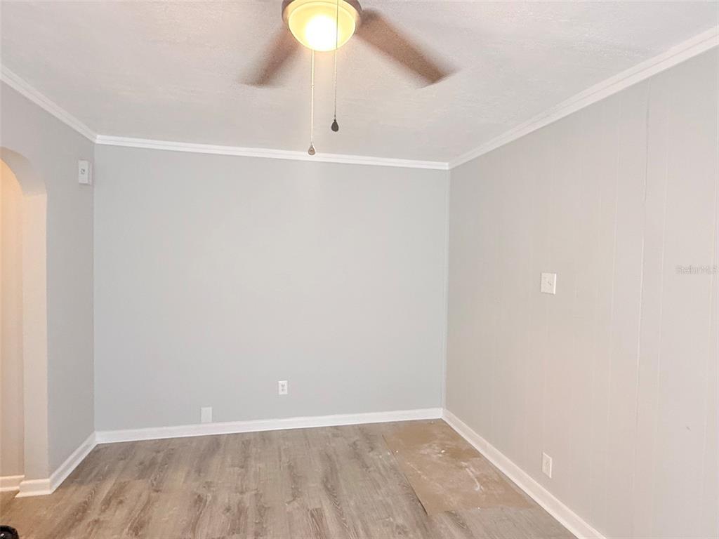 An empty room features light gray walls, white trim, and wood-look laminate flooring — 776 27TH AVENUE N, ST PETERSBURG, FL