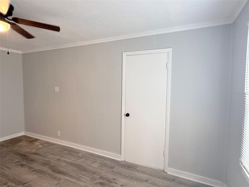 A room with gray walls, wood-look flooring, a ceiling fan, and a white interior door — 776 27TH AVENUE N, ST PETERSBURG, FL