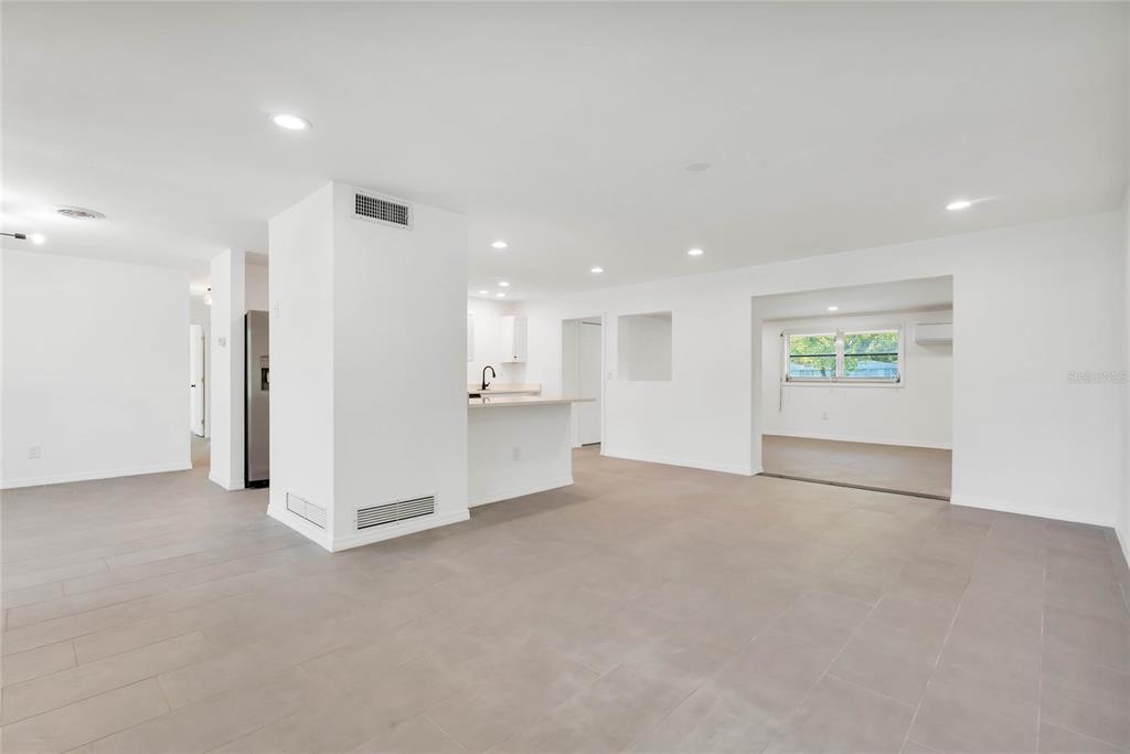 An open-concept living area features white walls, recessed lighting, and light gray tile flooring — 448 RIDGE DRIVE, SANFORD, FL