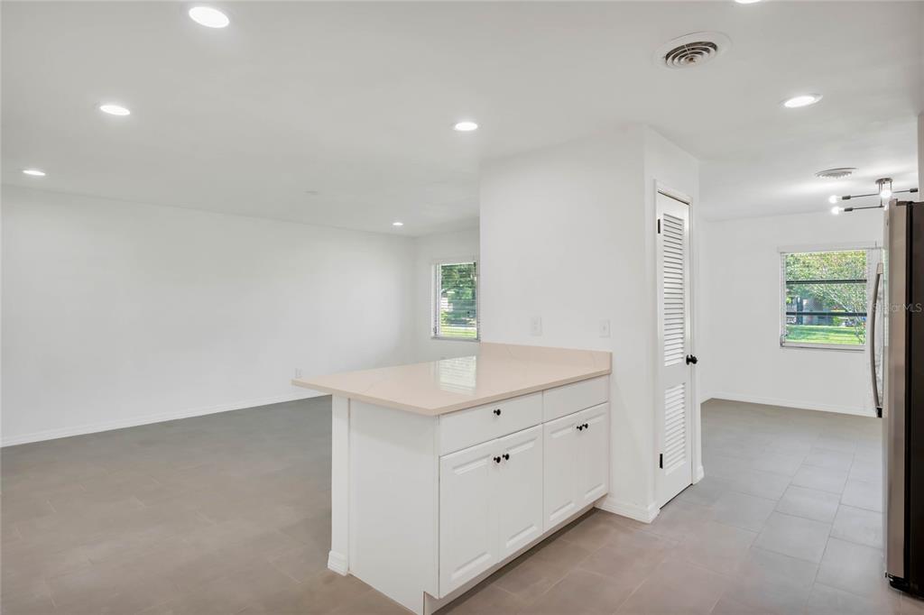 A white kitchen island with a light countertop sits in a room with tiled floors — 448 RIDGE DRIVE, SANFORD, FL