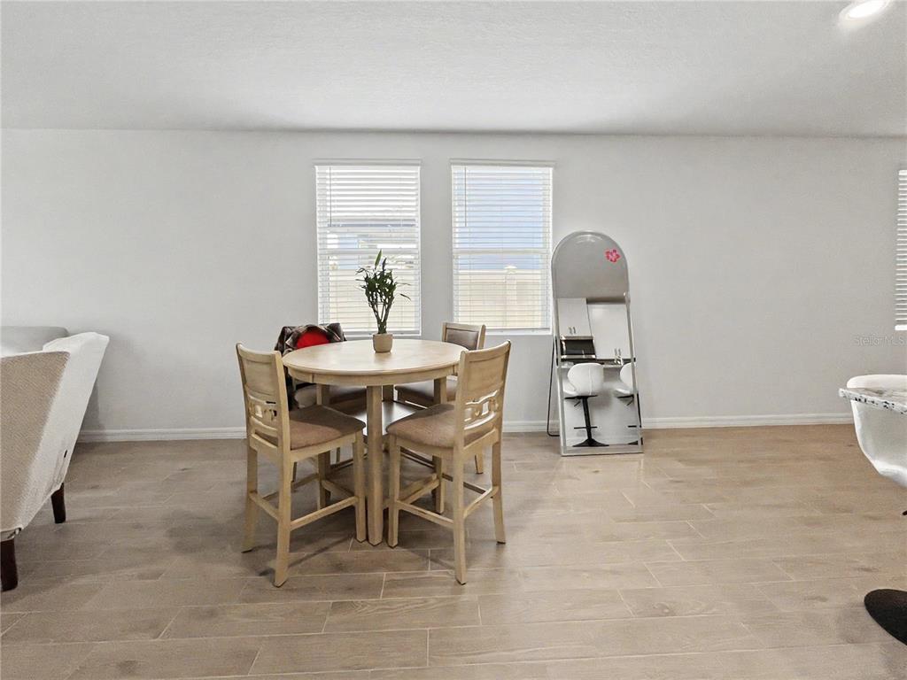 A dining area features a round wooden table, four chairs, and a floor-length mirror — 137 WHITELAND BEND, NOKOMIS, FL