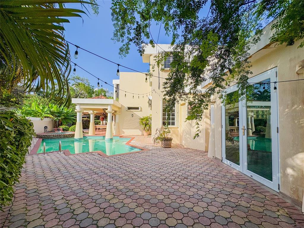 A backyard patio with a swimming pool, covered gazebo, and string lights against a house — 21 PQUE. TIVOLI | PASEO DEL PARQUE, SAN JUAN, PR