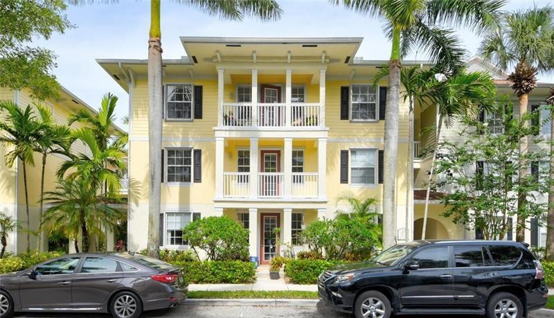 A three-story yellow apartment building with balconies and palm trees in front — 275 Murcia Drive # 208, Jupiter FL 33458, JUPITER, FL