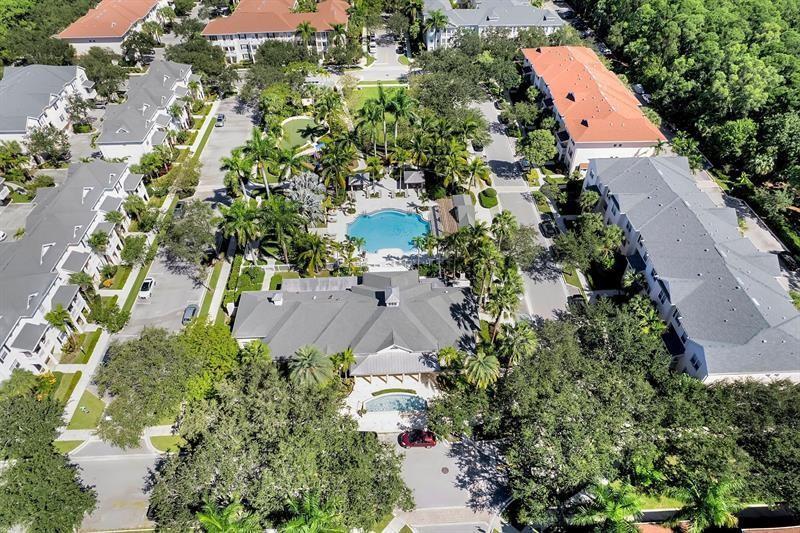 An aerial view shows a residential complex with a central swimming pool and surrounding buildings — 275 Murcia Drive # 208, Jupiter FL 33458, JUPITER, FL