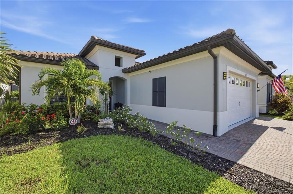 A screened-in swimming pool and spa with stone decking and lush tropical landscaping — 2110 E 6TH STREET W, PALMETTO, FL