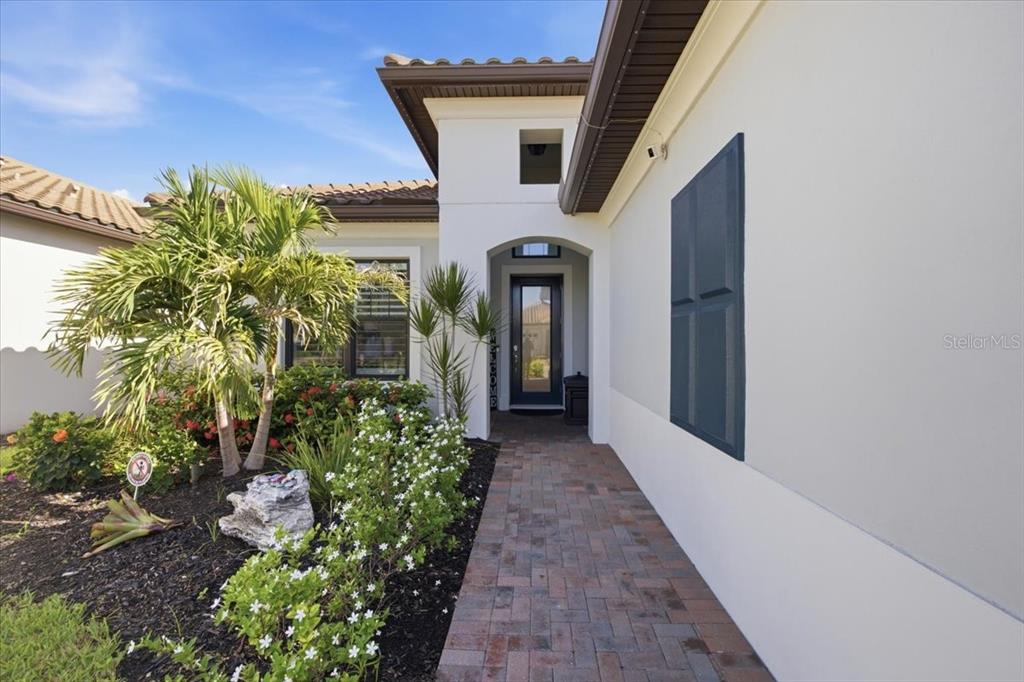 An outdoor kitchen features blue cabinets, granite countertops, a stainless steel grill, and a pizza oven — 2110 E 6TH STREET W, PALMETTO, FL