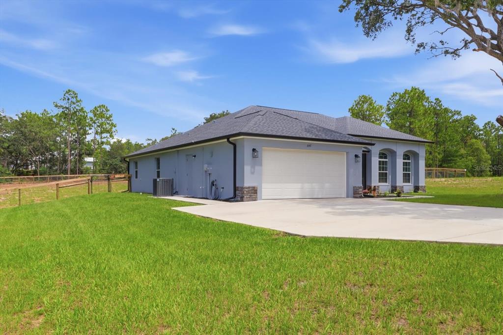 A light blue single-story house with a two-car garage and a concrete driveway — 6147 W SETTLER DRIVE, BEVERLY HILLS, FL