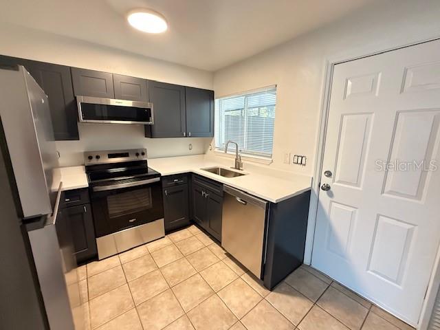 A kitchen features dark cabinets, stainless steel appliances, white countertops, and tiled flooring — 137 GARDEN DRIVE, WINTER SPRINGS, FL