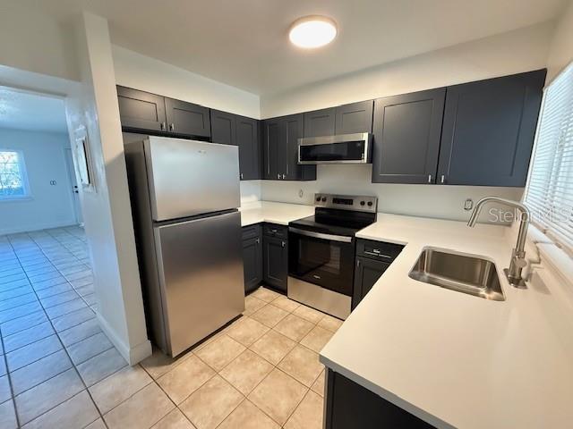 A kitchen features dark gray cabinets, stainless steel appliances, and white countertops — 137 GARDEN DRIVE, WINTER SPRINGS, FL