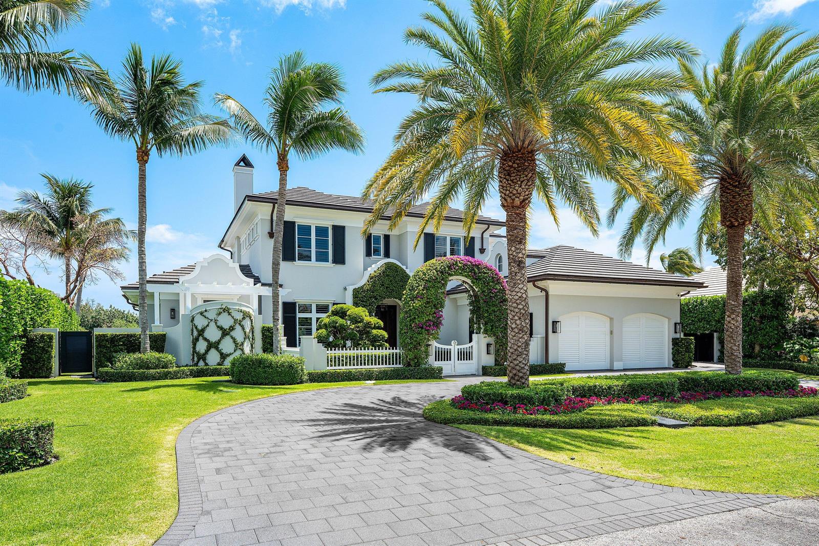 A two-story white house with a paved driveway, palm trees, and a flowering arched entryway — 2530 Avenue Au Soleil, Gulf Stream FL 33483, GULF STREAM, FL