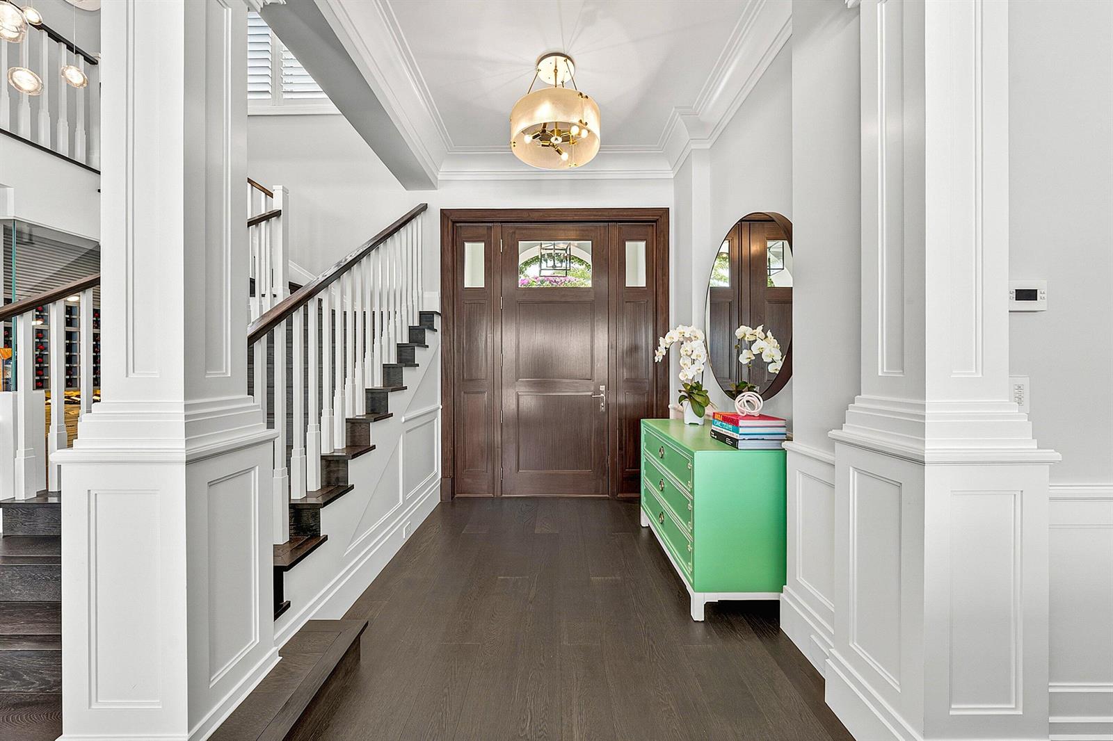 A bright foyer features a dark wood staircase, a green chest, and a wooden door — 2530 Avenue Au Soleil, Gulf Stream FL 33483, GULF STREAM, FL