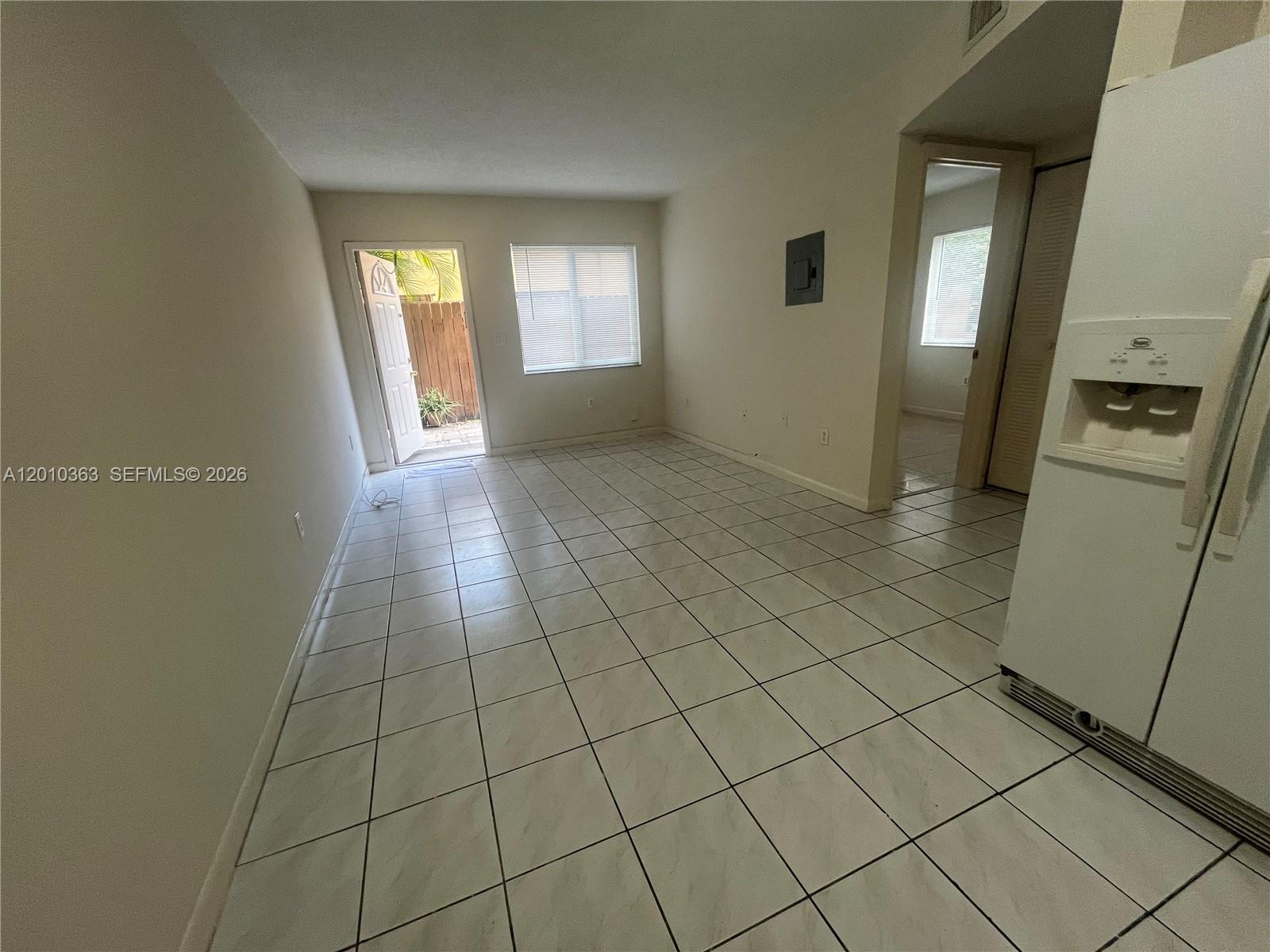 An interior view shows a tiled living area with a white refrigerator and open door — 1419 SW 22nd Ave # 4, Miami FL 33145, MIAMI, FL