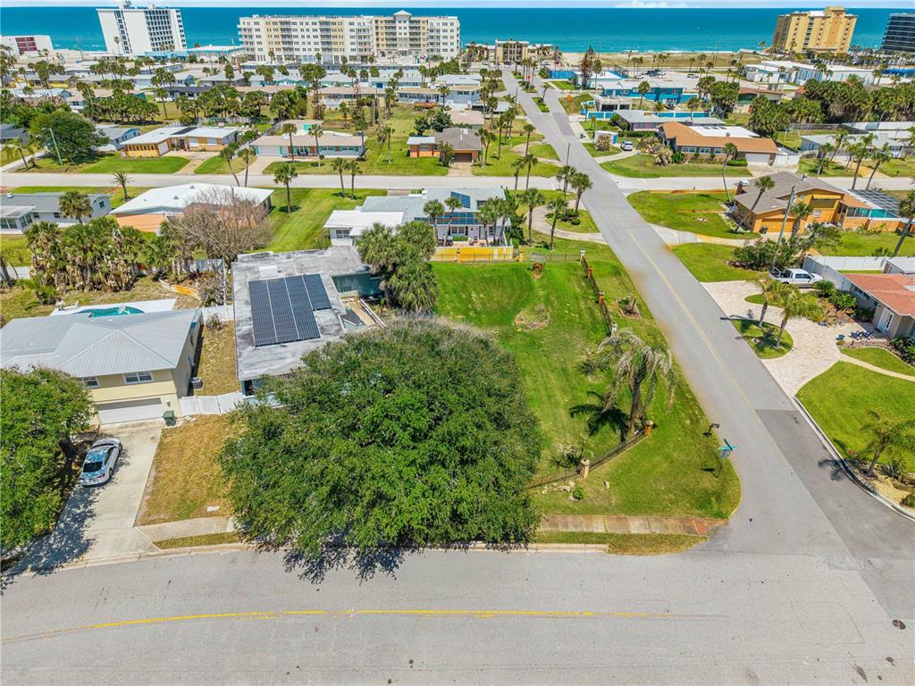 An aerial view shows a residential lot with a large tree and solar panels — 401 DRIFTWOOD AVENUE, DAYTONA BEACH, FL