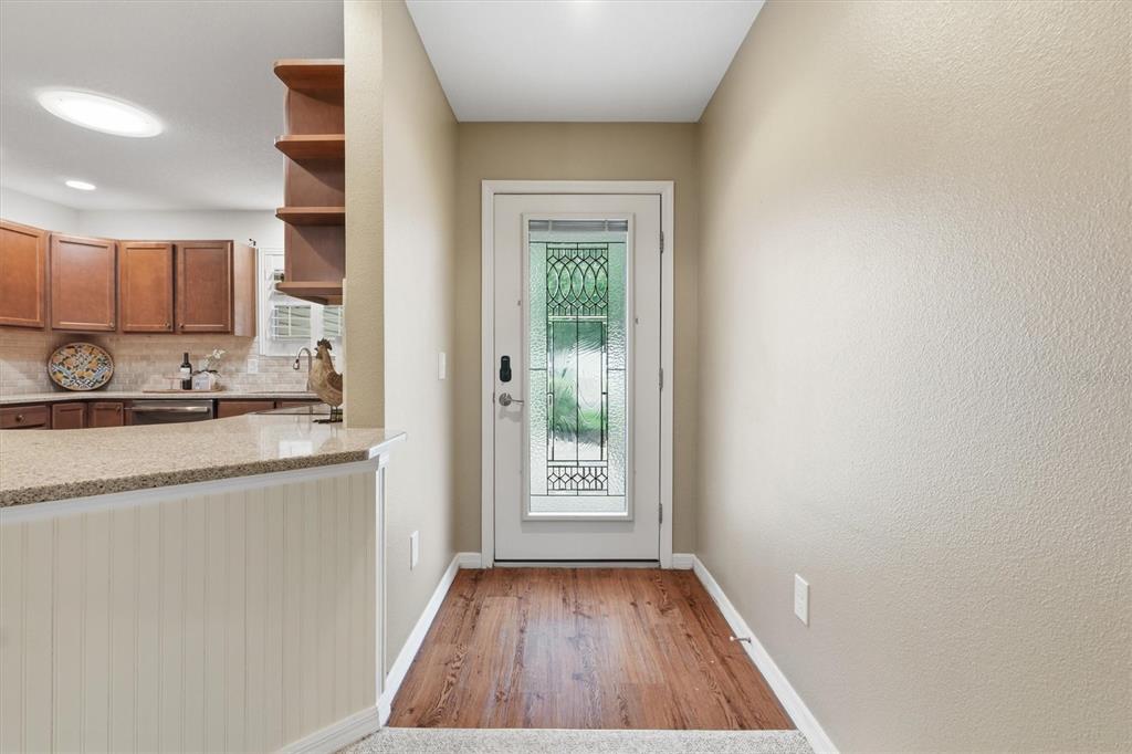 An entryway with wood-look flooring leads to a front door with a decorative glass insert — 2435 POMEROY TERRACE, THE VILLAGES, FL