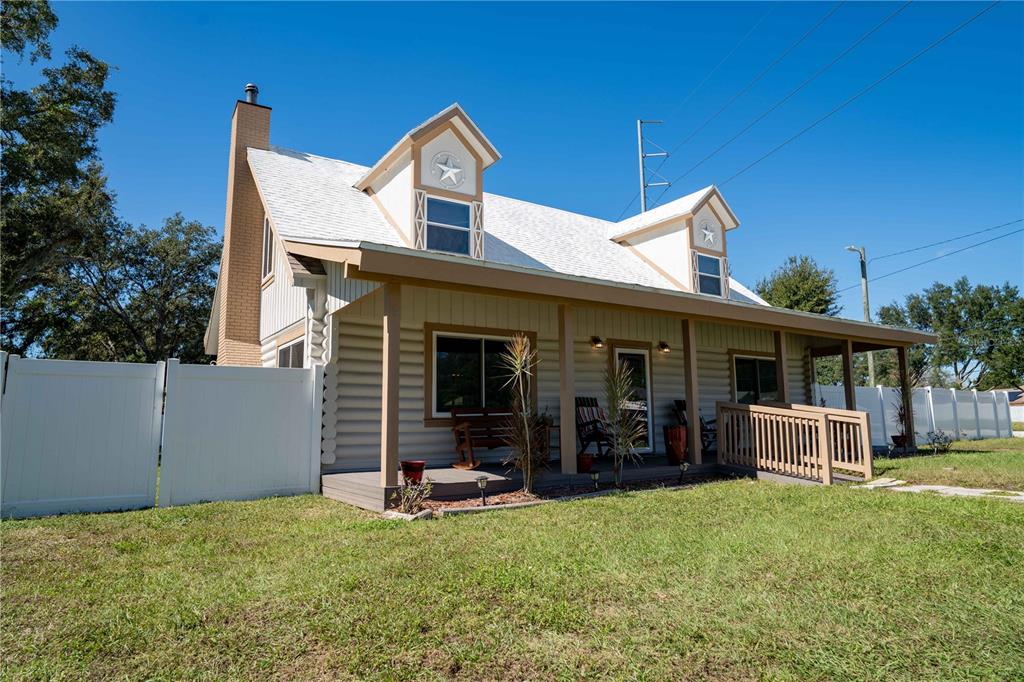 A two-story house with a white roof, dormer windows, and a covered front porch — 4599 REYNOSA DRIVE SW, WINTER HAVEN, FL