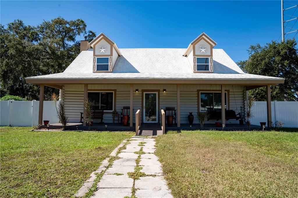 A one-story house with a white roof, two dormers, and a front porch — 4599 REYNOSA DRIVE SW, WINTER HAVEN, FL