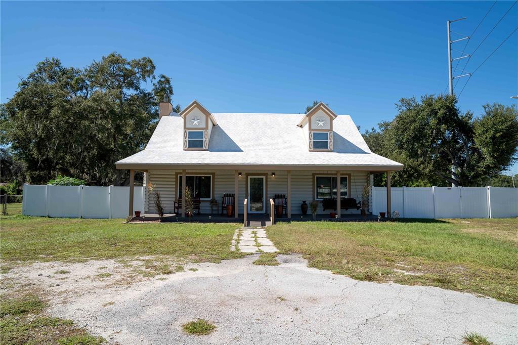 A two-story house with a white roof, dormer windows, and a covered front porch — 4599 REYNOSA DRIVE SW, WINTER HAVEN, FL