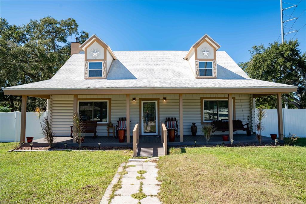 A one-story house with a covered porch, two dormer windows, and a white roof — 4599 REYNOSA DRIVE SW, WINTER HAVEN, FL