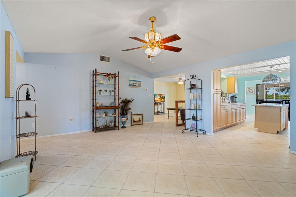 A spacious living area with light blue walls, tile flooring, and a ceiling fan — 174 SPRING LAKE BOULEVARD NW, PORT CHARLOTTE, FL